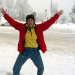 Picture of Patricia with arms raised celebrating a snowfall in front of the Northfield Common!
